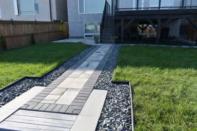 Barkman Broadway paver sidewalk with black granite edging and sod completed by Genesis Interlocking & Custom Landscaping in Winnipeg