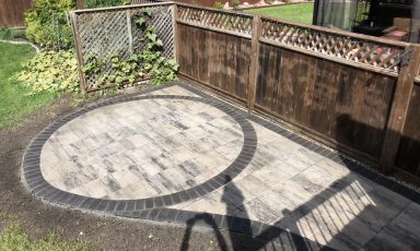 Barkman Lexington slab patio with custom circle inlay completed by Genesis Interlocking & Custom Landscaping in Winnipeg