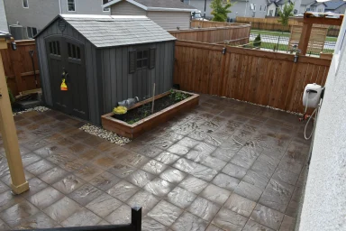 Barkman Brookside slab patio with garden box and shed completed by Genesis Interlocking & Custom Landscaping in Winnipeg