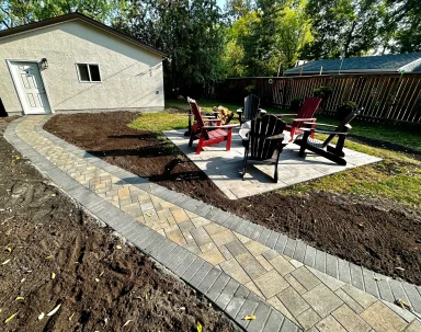 Belgard Dimensions 6 back sidewalk with fire pit patio and seating completed by Genesis Interlocking & Custom Landscaping in Winnipeg