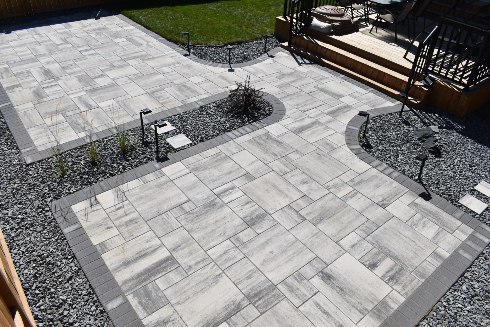 Genesis Interlocking & Custom Landscaping backyard hardscaping installation - Barkman Broadway slabs with border & landscaping - Landscaping Gallery Winnipeg