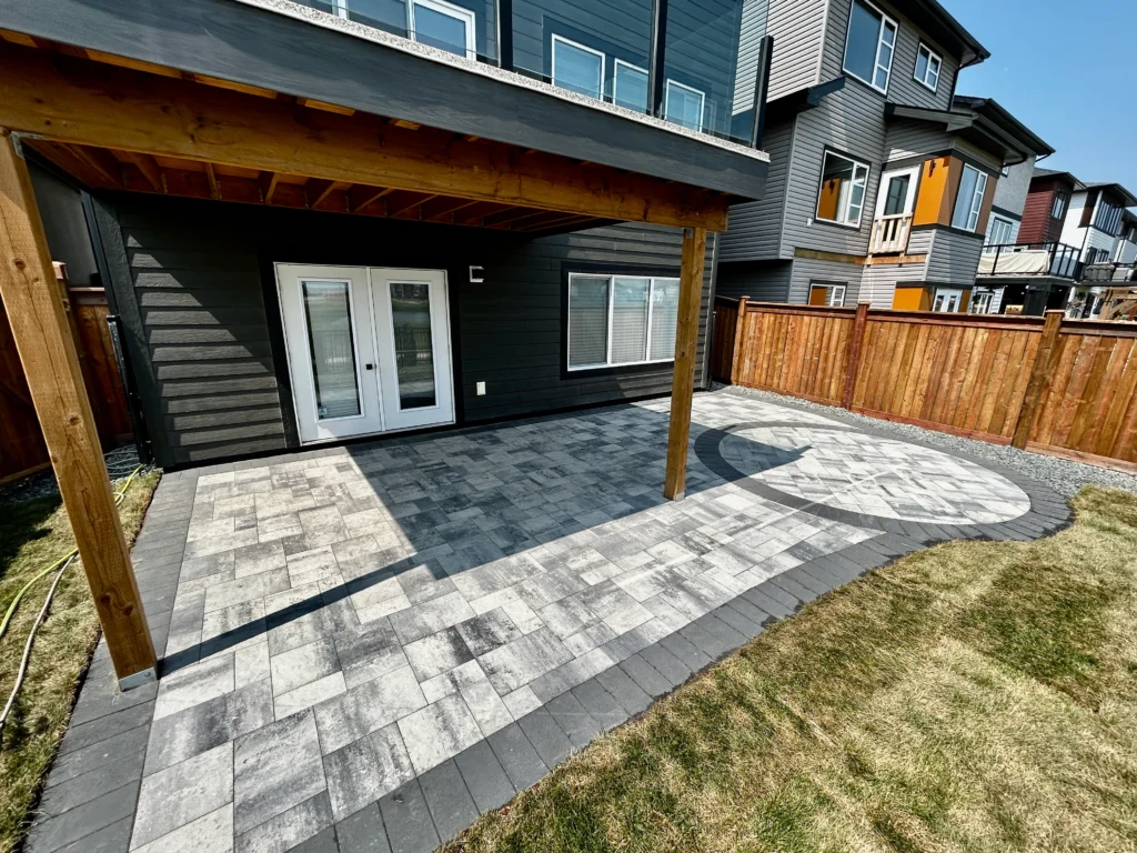 Backyard hardscaping installation - Belgard dimension pavers with circle fire pit inlay