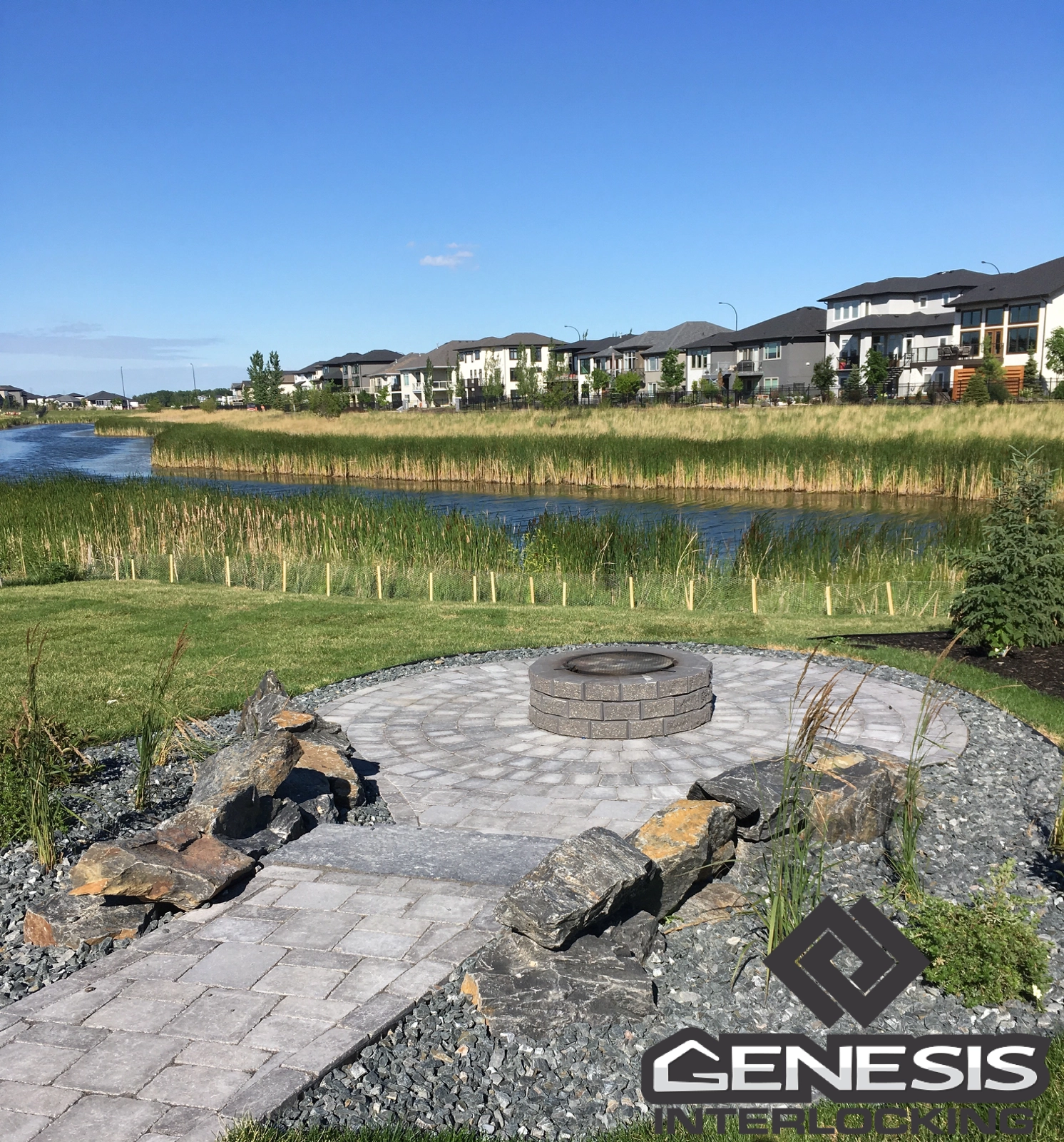 Genesis Interlocking & Custom Landscaping - Custom backyard landscaping - sunken patio with fire pit, boulder wall, plants, sod