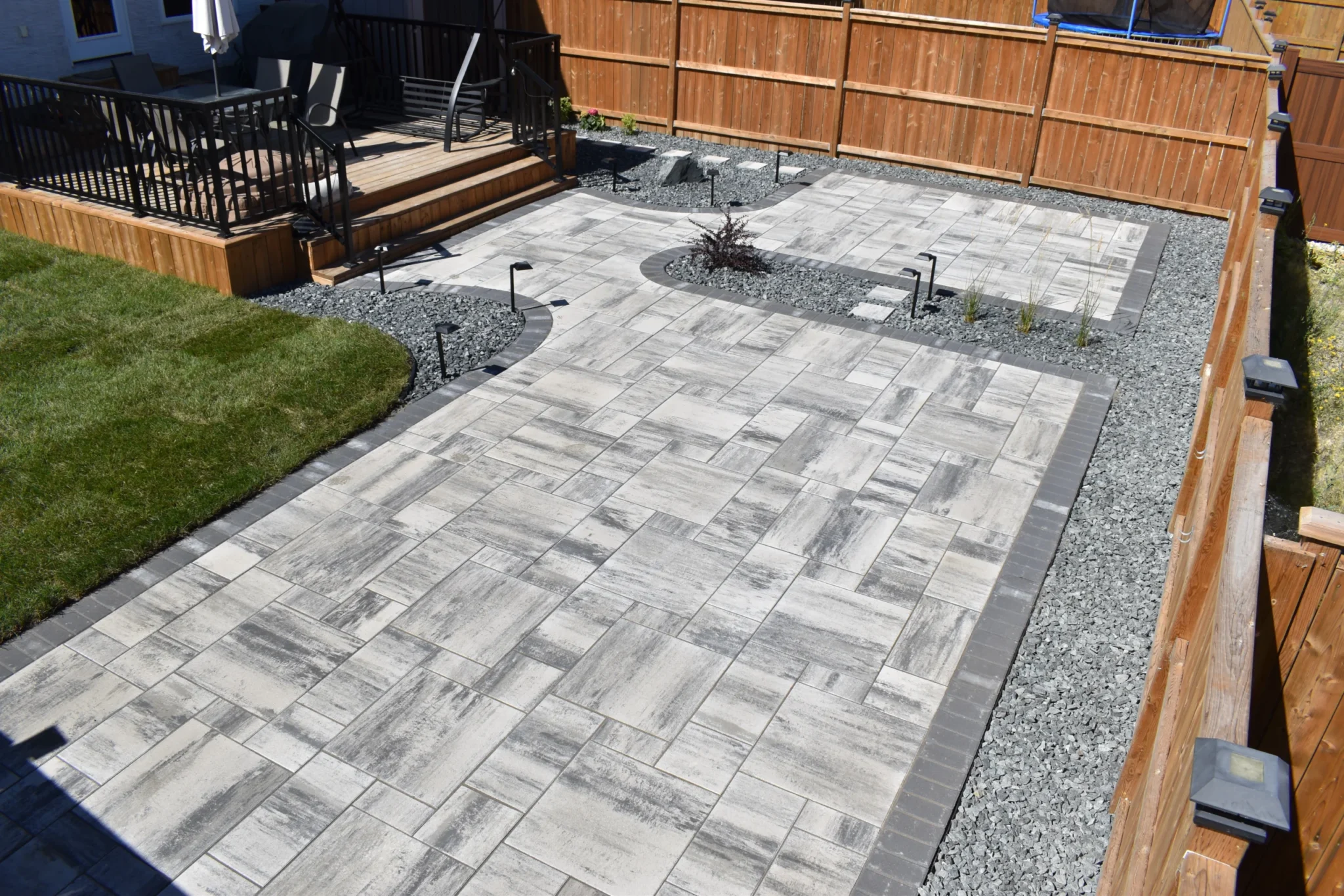 Genesis Interlocking & Custom Landscaping backyard hardscaping installation - Barkman Broadway slabs with border & landscaping - Landscaping Gallery Winnipeg