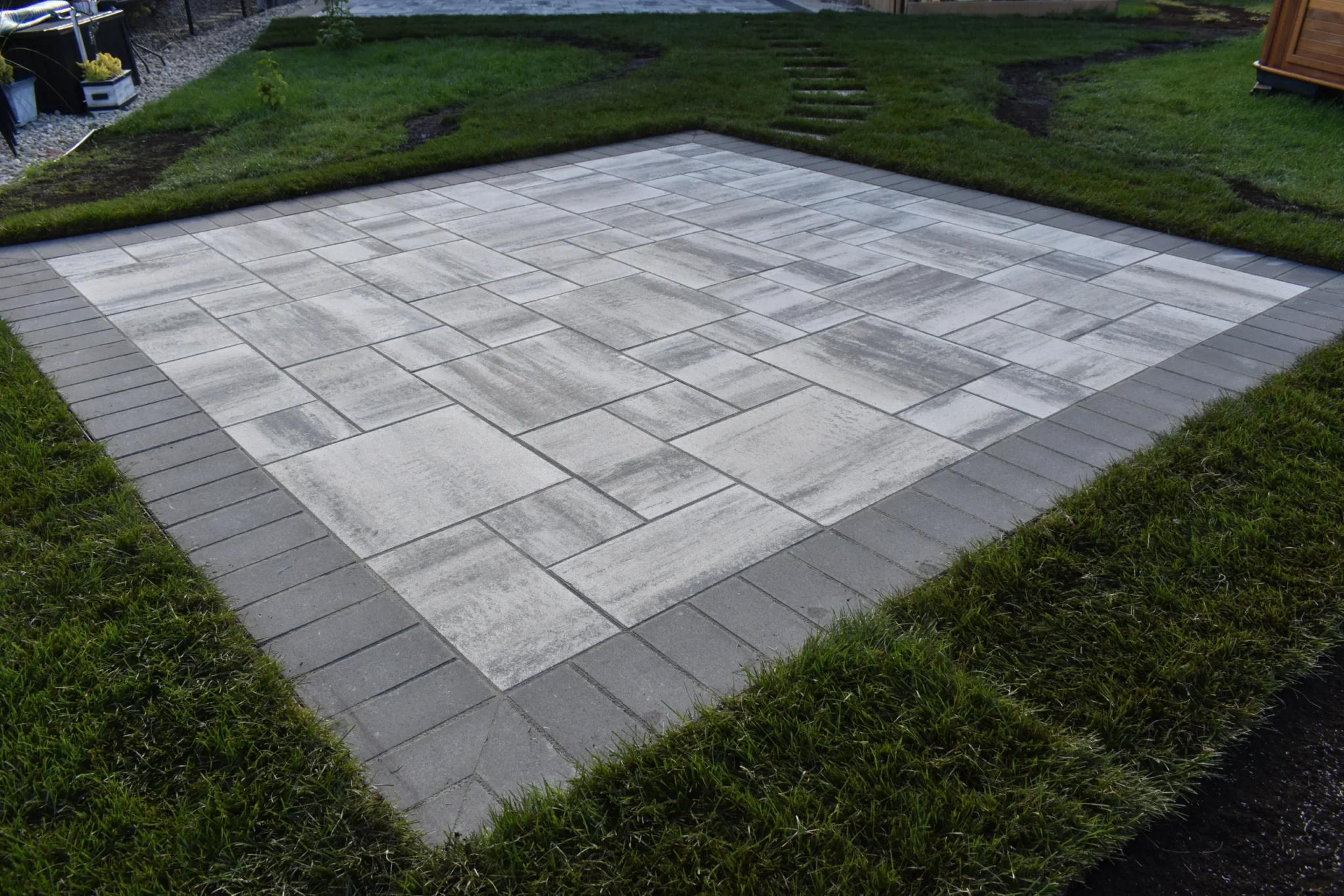 Genesis Interlocking & Custom Landscaping backyard hardscaping installation - Barkman Broadway slabs with border & landscaping  - Interlocking Patios Winnipeg