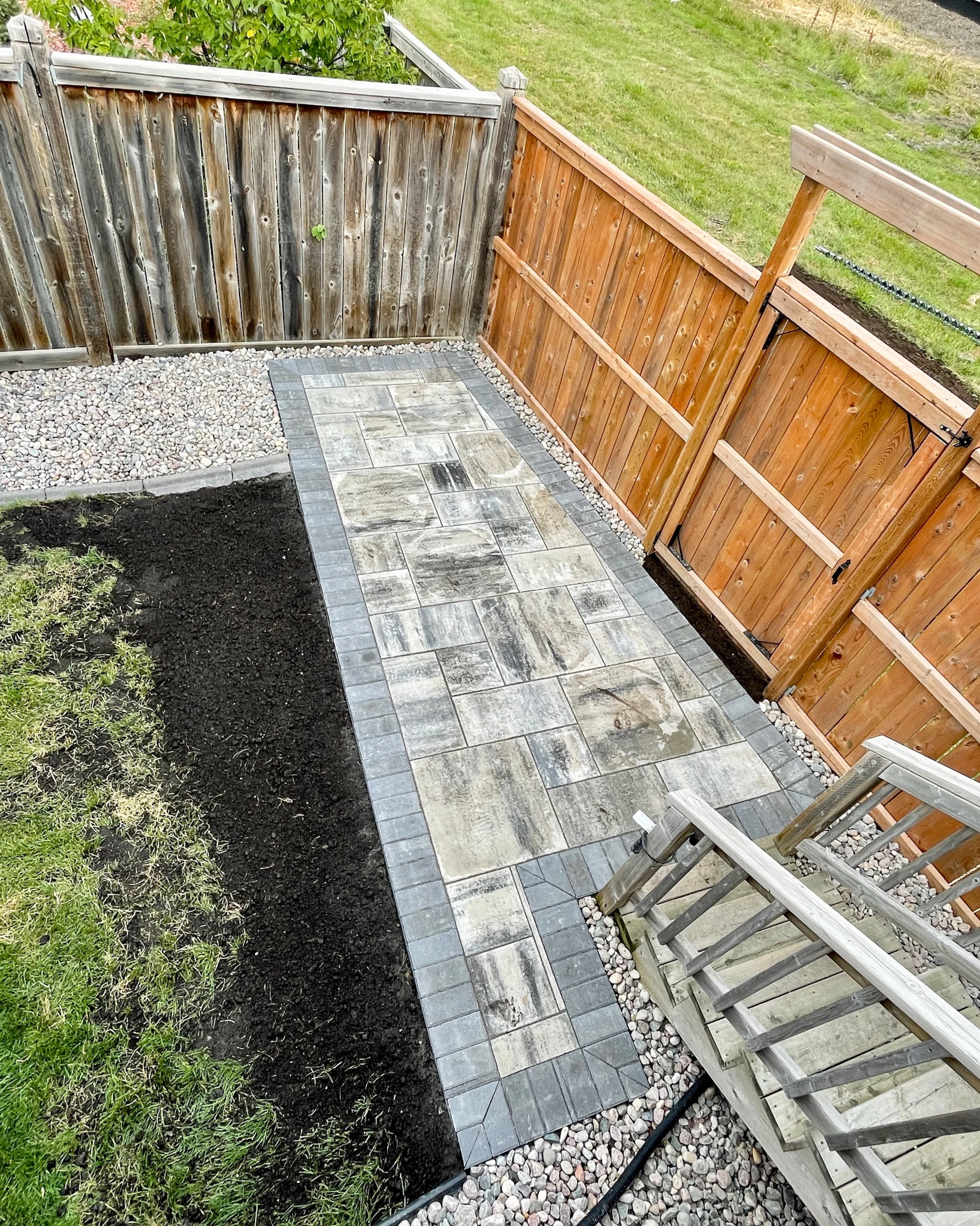 Genesis Interlocking & Custom Landscaping backyard hardscaping installation - Barkman Broadway slabs with border & landscaping - Interlocking Patios Winnipeg