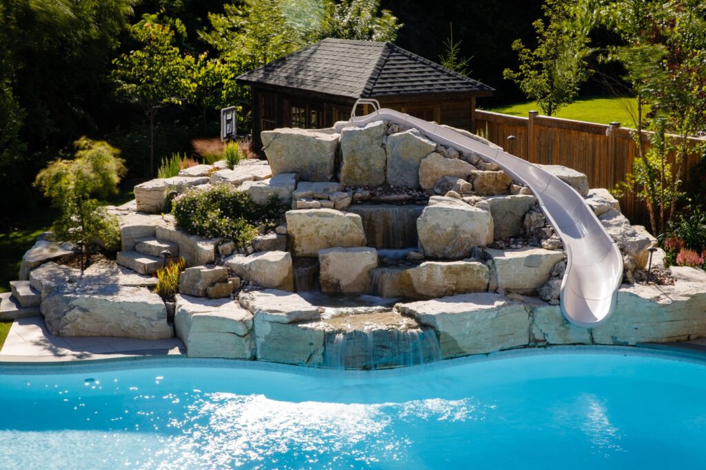 Fiberglass pool water slide and fountain - natural stone & landscaping 