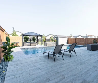 Barkman Arborwood Slab pool deck with lawn chairs completed by Genesis Interlocking & Custom Landscaping