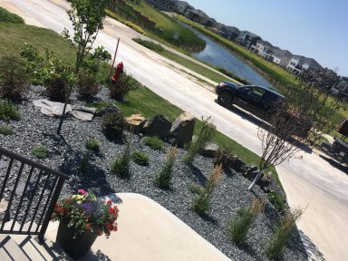 Front yard decorative rock with perennials completed by Genesis Interlocking & Custom Landscaping