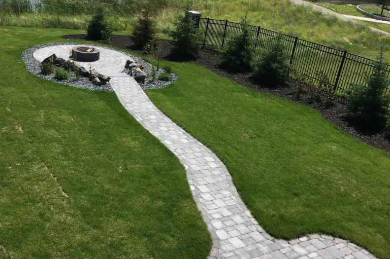 Barkman Roman paver sidewalk leading to sunken circle firepit area surrounded by fresh Kentucky Blue sod completed by Genesis Interlocking & Custom Landscaping