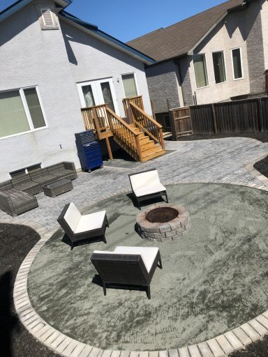 Discontinued Barkman paver patio with black granite circle fire pit area completed by Genesis Interlocking & Custom Landscaping