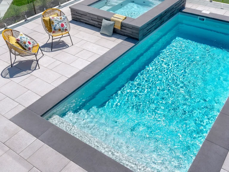 Modern design fiberglass pool & spa with an interlocking patio