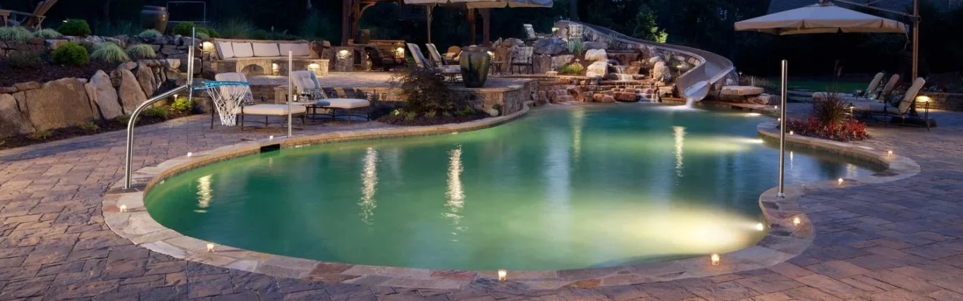Custom landscaped backyard with inground swimming pool, waterslide and basketball net