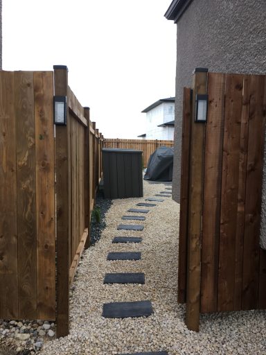 Pressure treated 4x4 fence with solar lights and gate completed by Genesis Interlocking & Custom Landscaping