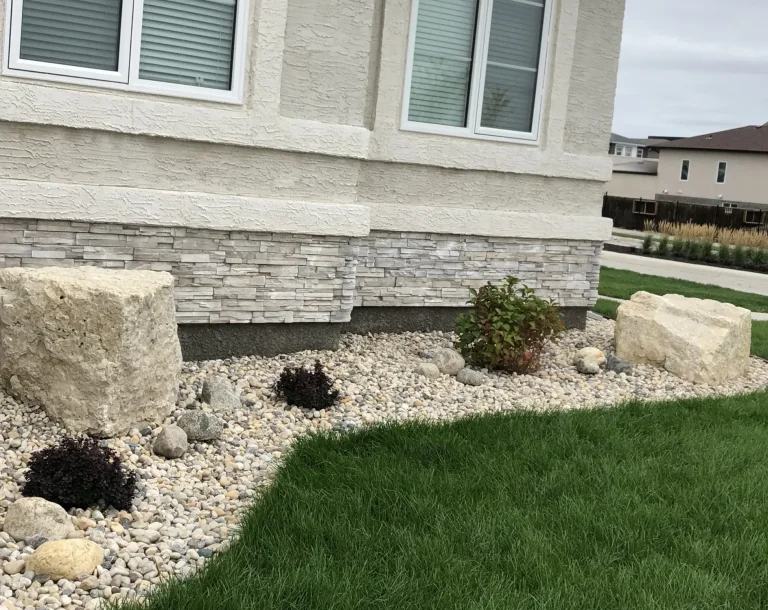 Limestone boulders on top of river rock decorative stone completed by Genesis Interlocking & Custom Landscaping