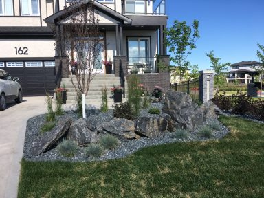 Front yard decorative rock and perennials completed by Genesis Interlocking & Custom Landscaping