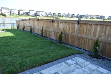 Pressure treated 6x6 fence with solar lights completed by Genesis Interlocking & Custom Landscaping