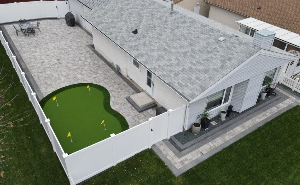 Full property landscaping and hardscaping in Winnipeg manitoba, barkman broadway paver patio and sidewalks, putting green, flower gardens, vinyl fencing and plants